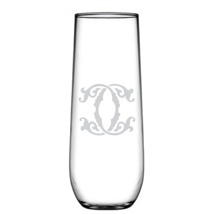 The 1-Letter Monogrammed Stemless Champagne Flute is a tall, clear glass with a cylindrical shape and smooth, reflective surface. It features an intricate swirling design etched centrally, resembling a delicate personalized initial.