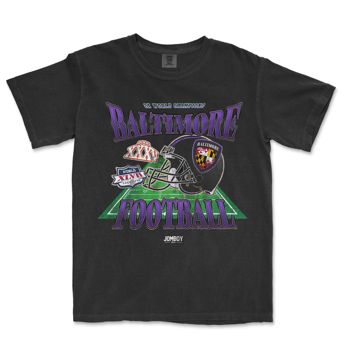 Black Comfort Colors T-shirt featuring a colorful Baltimore football graphic with helmet, patches, and "Baltimore Football" text.