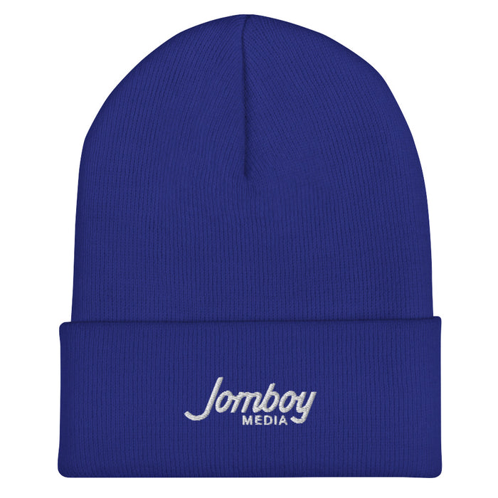 Blue beanie hat with "Jomboy Media" embroidered in white on the front cuff.