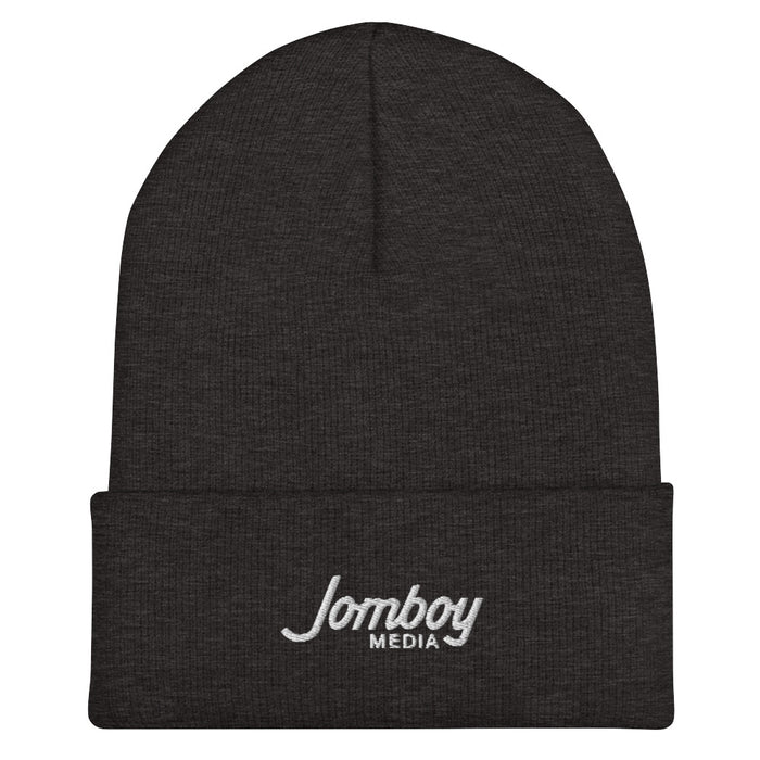 Black beanie hat with "Lomboy Media" embroidered in white on the front fold, designed for warmth and casual style.