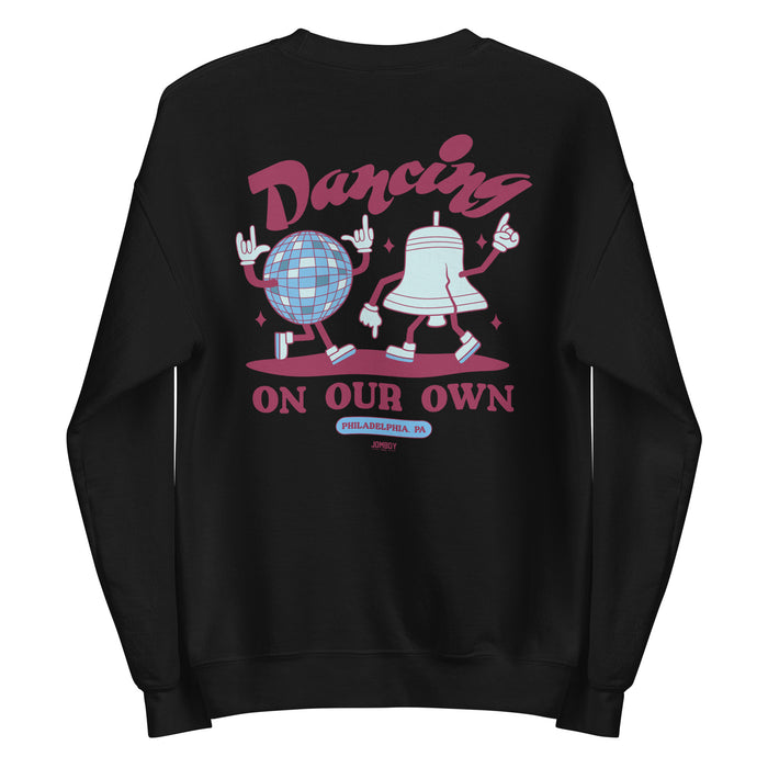Black crewneck sweatshirt featuring cartoon dancing figures of a disco ball and a bell, with "Dancing On Our Own" text and Philadelphia, PA location.