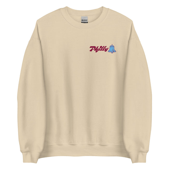 Beige crewneck sweatshirt featuring a small "Philly" text and bell graphic on the upper left chest area.