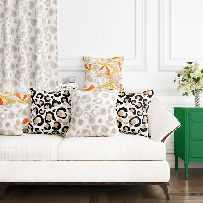 A white couch adorned with leopard print pillows and a vibrant pillow sits against a white wall. Nearby, a green side table holds flowers in a vase. The background showcases matching curtains made from the Fabric by the Yard - Neutral Cheetah, adding an exotic flair to the serene setting.