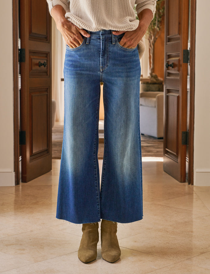 Person wearing blue jeans and brown boots indoors.
