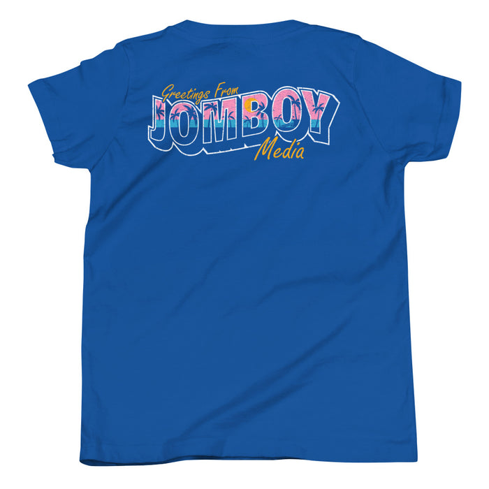 Blue youth T-shirt with colorful "Greetings from Jomboy Media" text and floral design, casual and vibrant.
