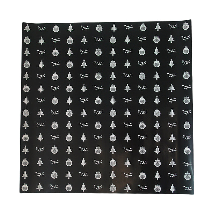 image of a square sheet of holiday wrapping paper on a white background. paper is black, with white christmas trees, ornaments and the words being as an ocean alternating throughout, filling the paper.