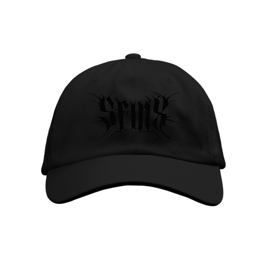 The SFINX black baseball cap features Seaux embroidered in a stylized gothic font on the front. Its solid black design stands out. Available for presale; shipping date provided at checkout.