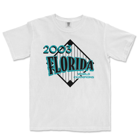 White Comfort Colors tee featuring a 2003 Florida World Champions graphic with a bridge illustration and bold blue and black text.