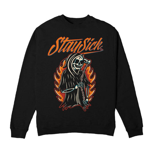 Stay Sick Clothing black crewneck sweatshirt with a flaming, grinning Grim Reaper holding a scythe, surrounded by orange flames. Bold “Stay Sick” text in orange is printed above the graphic.