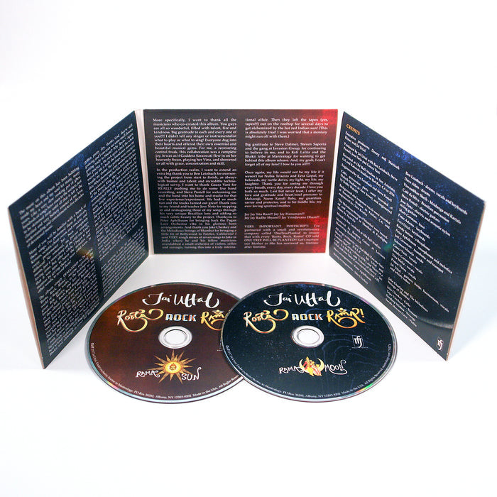 Two open Jai Uttal CD cases stand upright with detailed text inside, featuring H.E.L.P. and S.A.M.B.A. themes. In front are two CDs—one with a gold sun design, one with a silver moon—set against a dark, celestial backdrop.