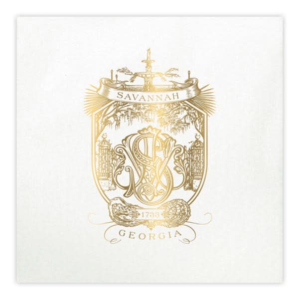 The Savannah Crest Cocktail Napkin Set in white and gold boasts intricate designs with a gold foil ornate crest on faux linen, elegantly displaying Savannah at the top and Georgia below. It features a monogram, fountain illustration, and marks the year 1733.