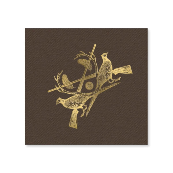 The Sporting Luxe Cocktail Napkins showcase two pheasants on crossed branches with antlers and a shotgun shell in gold foil, forming a striking crest on a textured dark brown background.