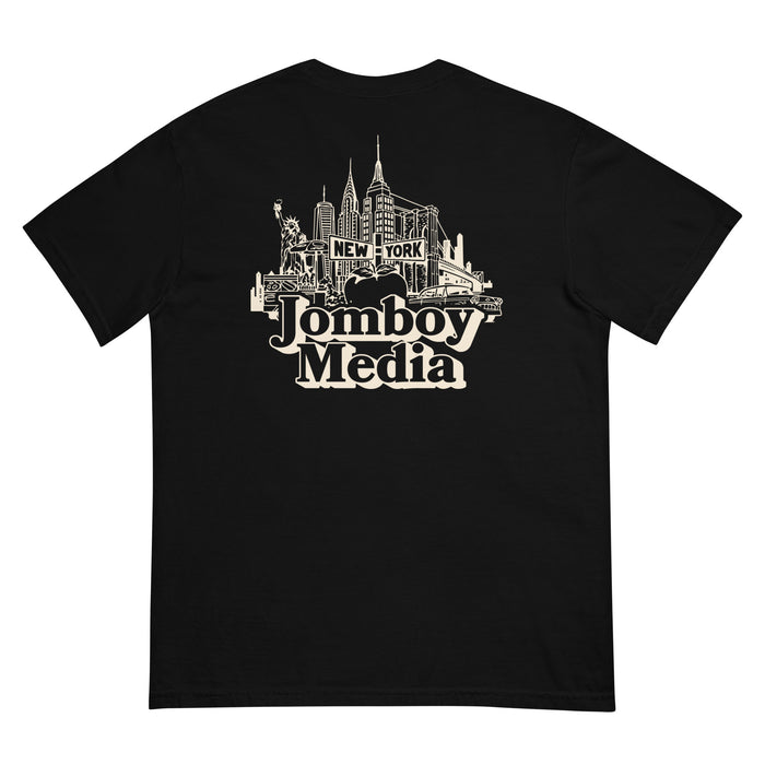 Black T-shirt featuring a white line art illustration of New York City skyline with iconic buildings, the Statue of Liberty, and a vintage car, along with the text "Jamboy Media" and "New York.