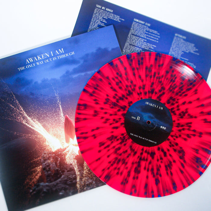 A pink vinyl LP with black splatter from Awaken I Am rests partly atop its album cover, which displays a rocket launch and the title The Only Way Out Is Through, with a lyrics sheet seen in the background.