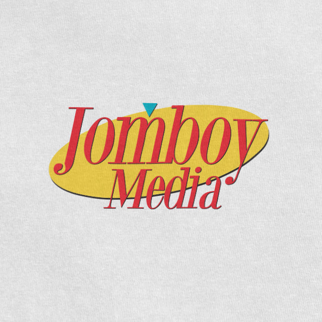 "Jomboy Media logo with red text on a yellow oval background and a small blue triangle above the 'j'.