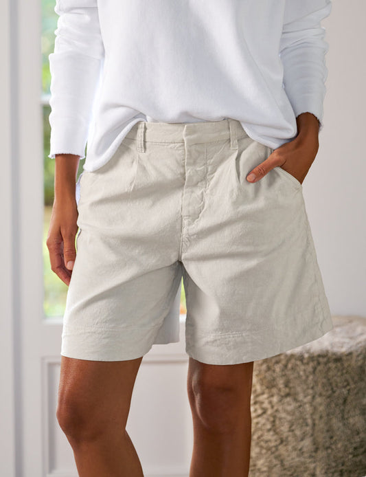 Person wearing light-colored shorts and a white top indoors.